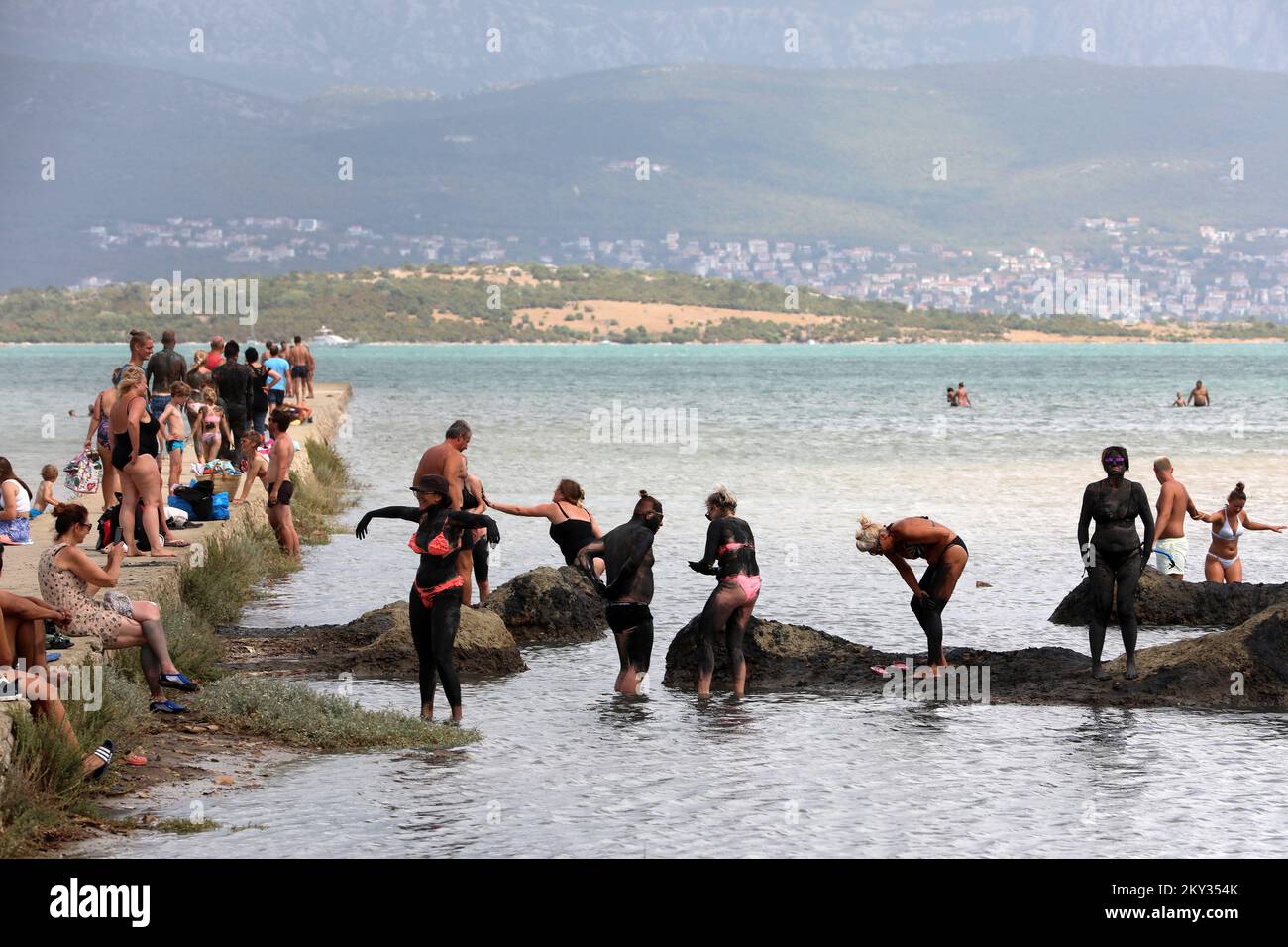 Bathers enjoy rubbing in the mud in Soline Bay on Krk Island, on Aug 19