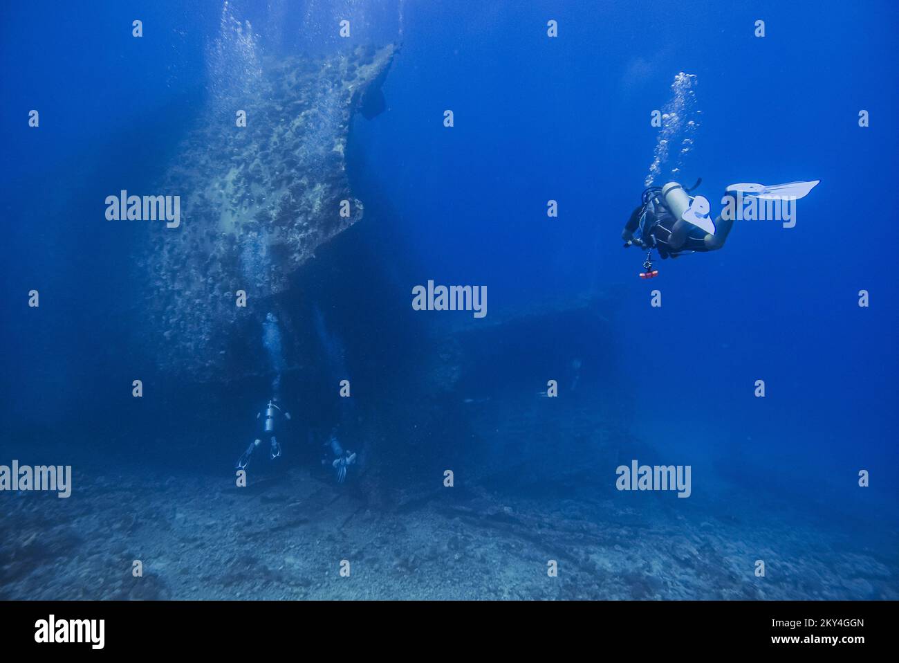 Scuba diver exploring the interior of a submerged wreck of Giannis D on September 30, 2022 in Hurghada, Red Sea, Egypt. In April 1983, Giannis D was loaded with lumber in Rijeka, Croatia, destined for Saudi Arabia and Yemen. The ship passed through the Mediterranean and through the Suez Canal. On 19 April 1983, it was approaching the Gobal Strait at full speed when it was seen to suddenly veer off course and crash heavily into the northwest corner of the Sha'ab Abu Nuhas ridge. The crew abandoned the ship and were safely rescued. The submerged wreck of Giannis D is located at a depth of 4 to 2 Stock Photo