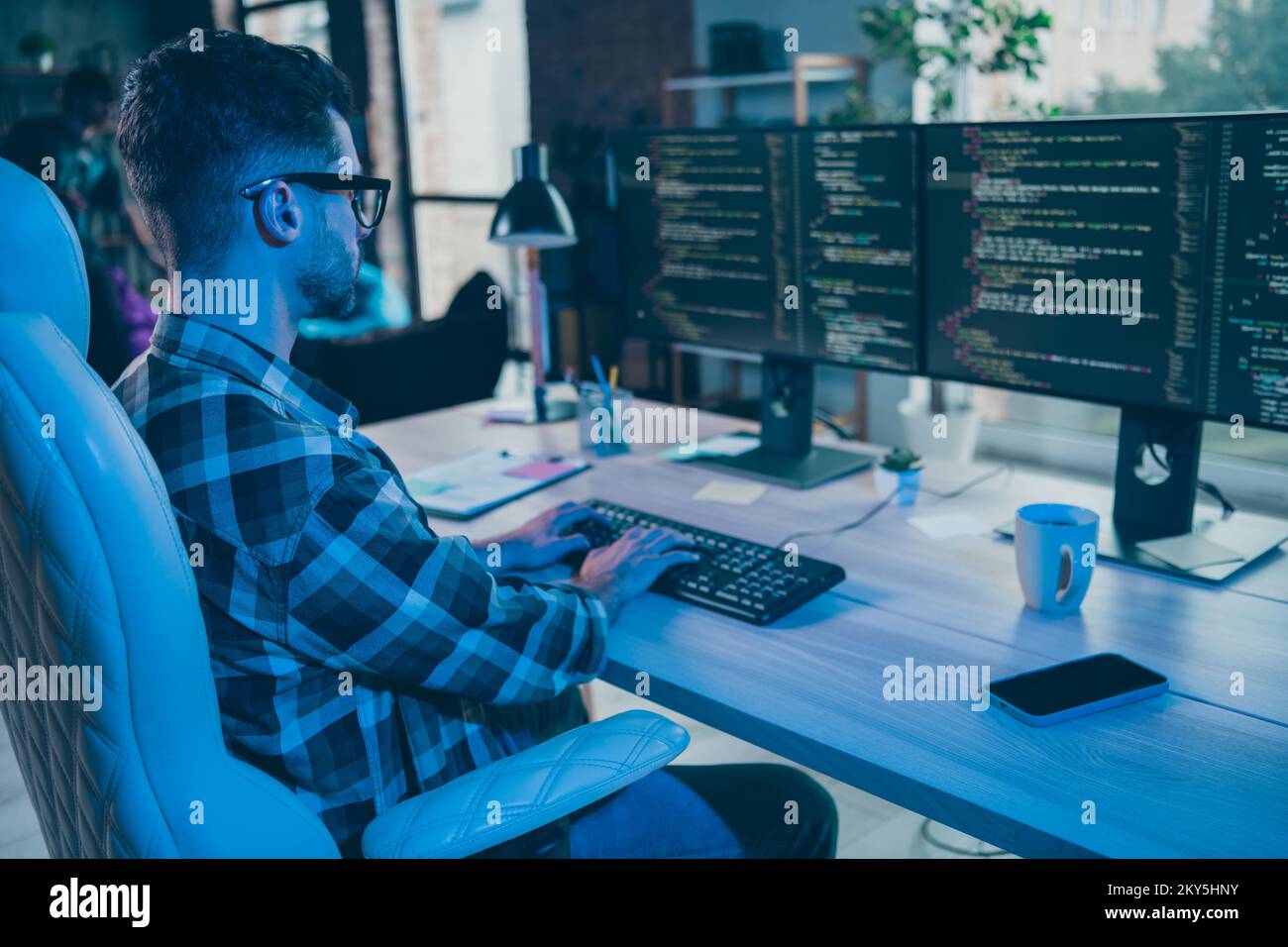 Photo of serious busy guy wear glasses writing safety code modern device indoors workstation workshop home Stock Photo