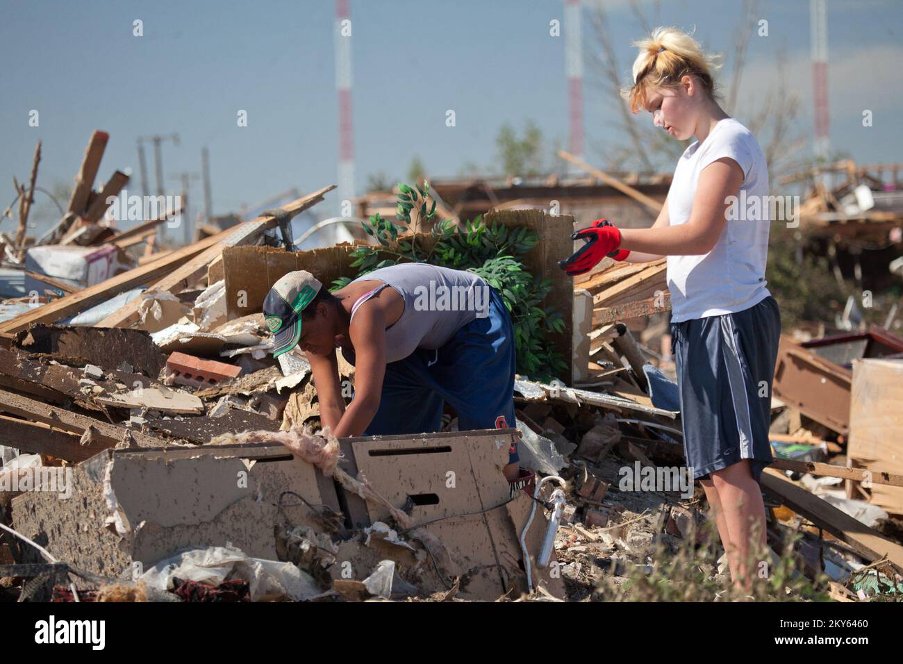 Moore, Okla., May 22, 2013   Moore residents, Sileah Morah and Derisha Jackson help a neighbor sift through debris to find his belongings after an F5 tornado struck the area. Andrea Booher/FEMA.. Photographs Relating to Disasters and Emergency Management Programs, Activities, and Officials Stock Photo