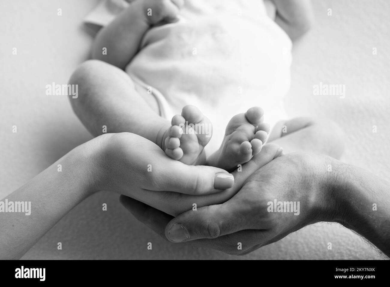 Baby feet in the hands of mother, father, older brother or sister, family. Stock Photo