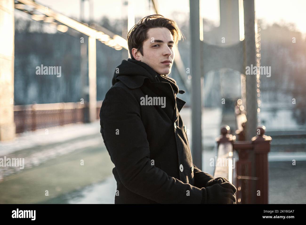 Portrait of a thoughtful hipster guy standing on the bridge Stock Photo