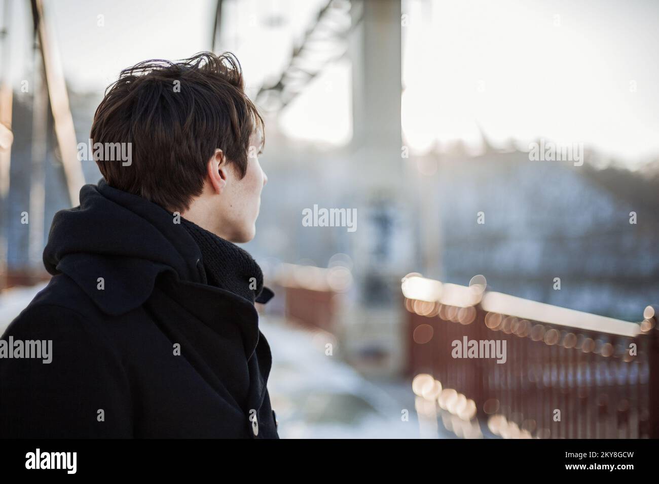 Hipster guy standing on the bridge looking away Stock Photo