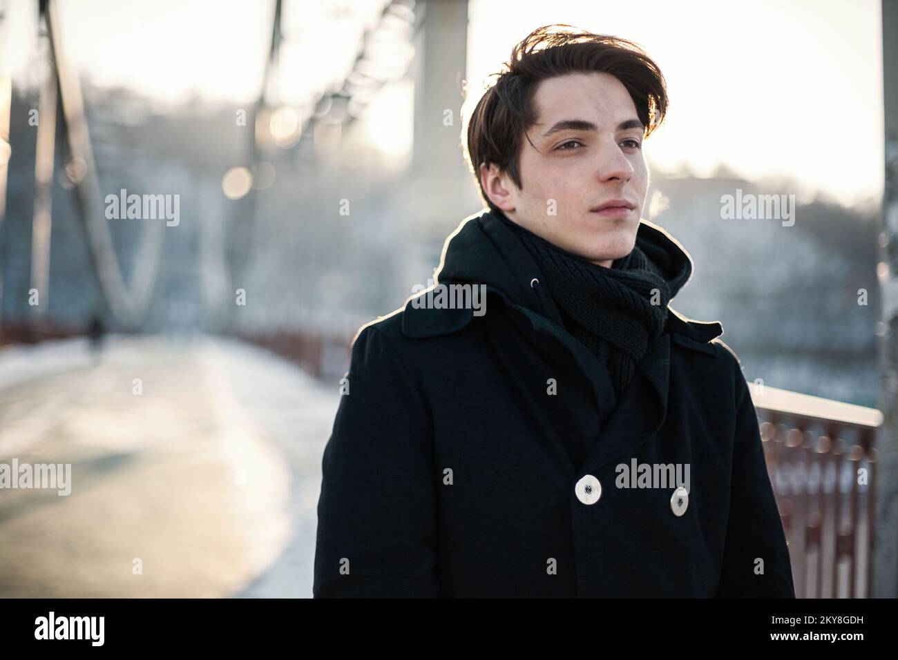 Thoughtful hipster guy walking on the bridge Stock Photo