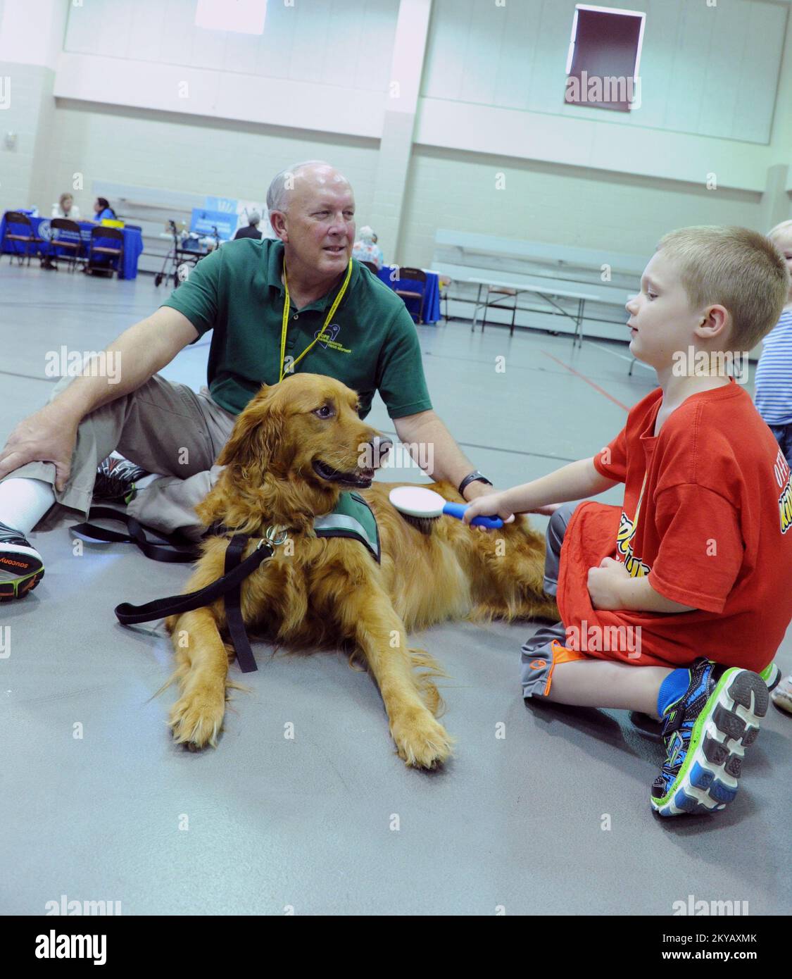 Houston, TX, June 10, 2015 Comfort dog Kenny gets a brushing by local  resident Holden Fuerst, right, while HOPE Animal-Assisted Crisis response  volunteer Pete Rouse, left, looks on at the Multi Agency
