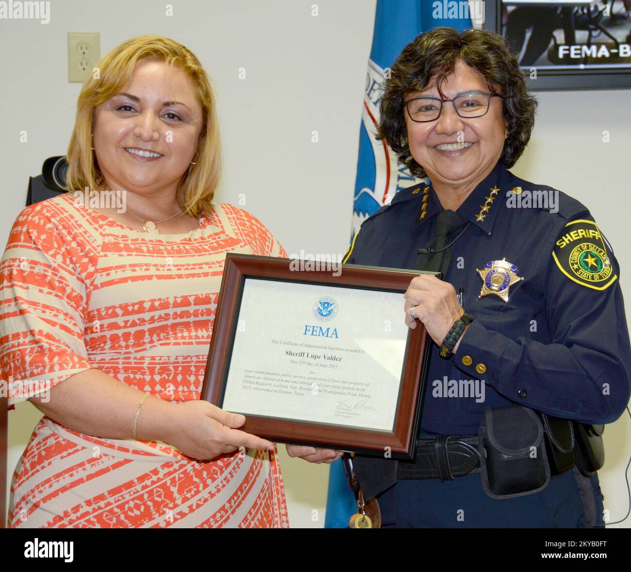 FEMA Region VI Equal Rights Advisory Council Deputy Chairperson Patricia Mancha resents Dallas County Sheriff Lue Valdez with a plaque commemorating her participation for LGBT Pride Month at Region VI... Photographs Relating to Disasters and Emergency Management Programs, Activities, and Officials Stock Photo
