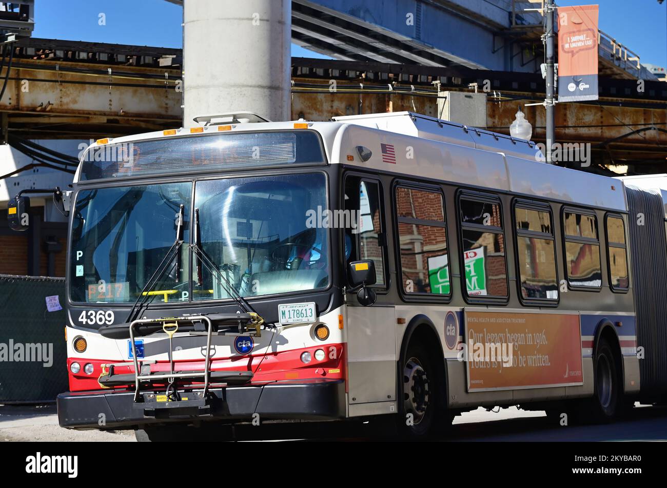 Chicago, Illinois, USA. An articulated bus on Clark Street passes under L tracks on its journey to downtown Chicago and the city's famous Loop. Stock Photo