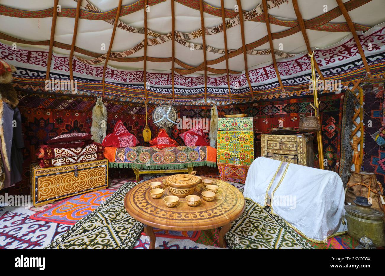 An interior view of a typical yurt, complete with rugs, carpets, clothes and other home posessions. At the Local History Museum in Karaganda, Kazakhst Stock Photo