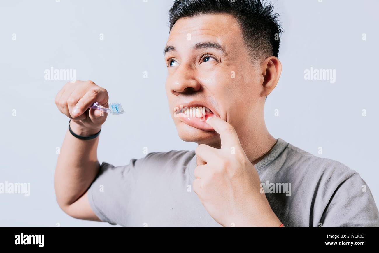 Man holding toothbrush with gum pain isolated, People holding