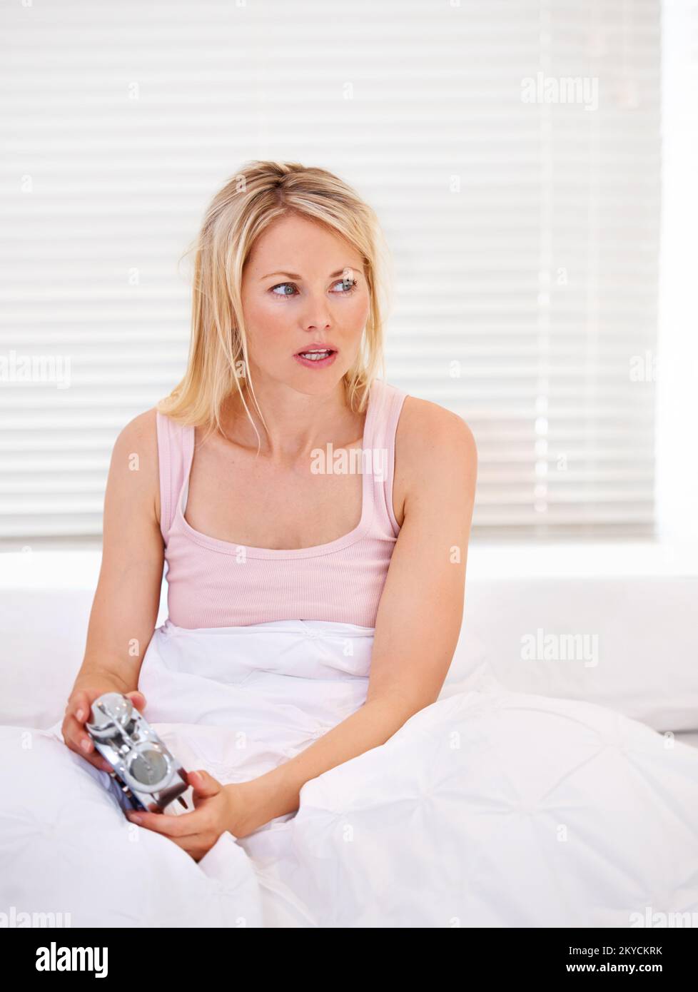 It cant be that time already. A tired woman waking up with her alarm