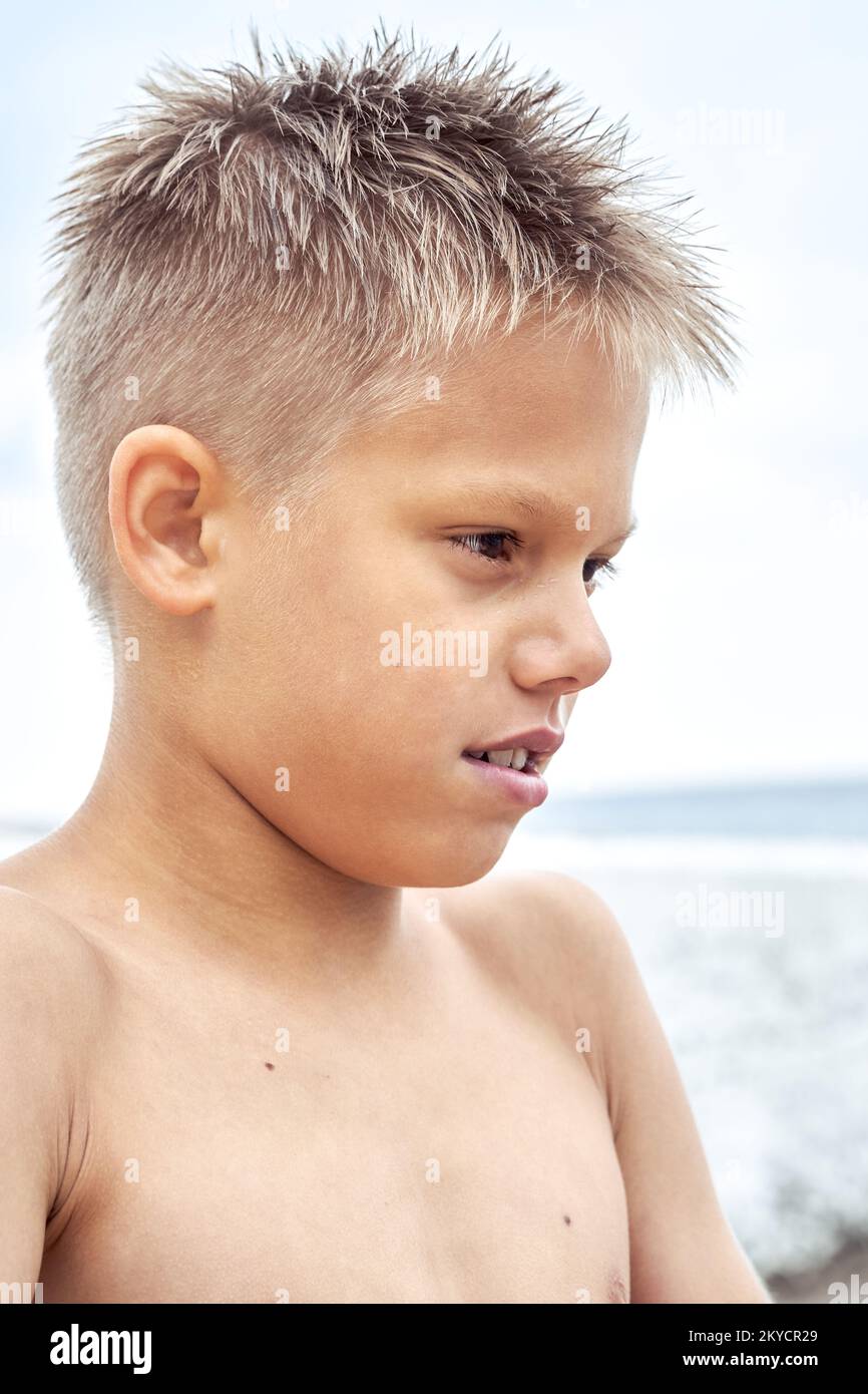 Boy with blue lips frozen from swimming in cold water at sea resort