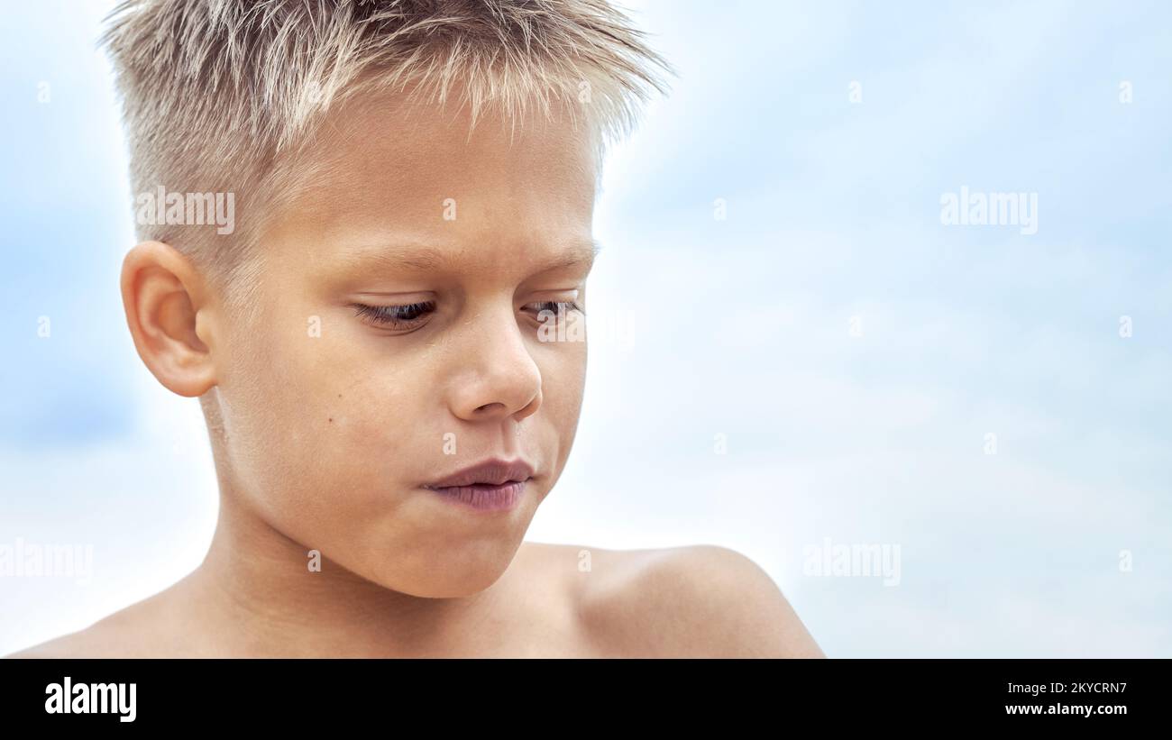Boy with blue lips frozen from swimming in cold water at sea resort