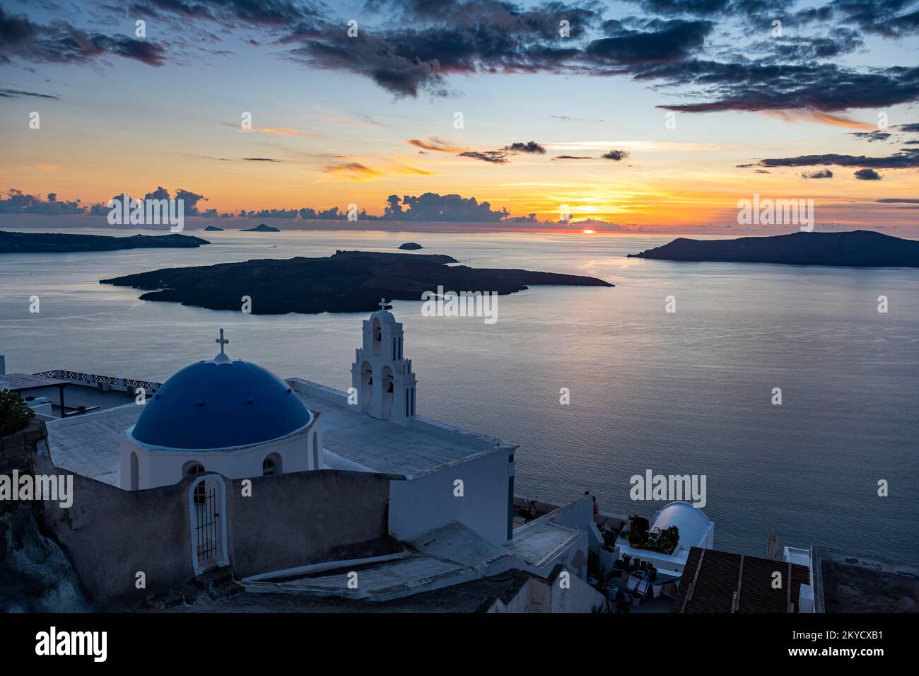 Sunset over the volcanic islands of Santorini and Anastasi Orthodox Church at sunset, Fira, Santorini, Greece Stock Photo