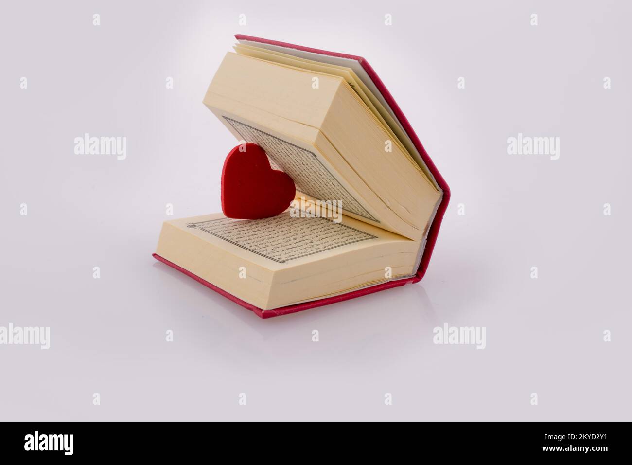 The Holy Quran with a heart on a white background Stock Photo - Alamy