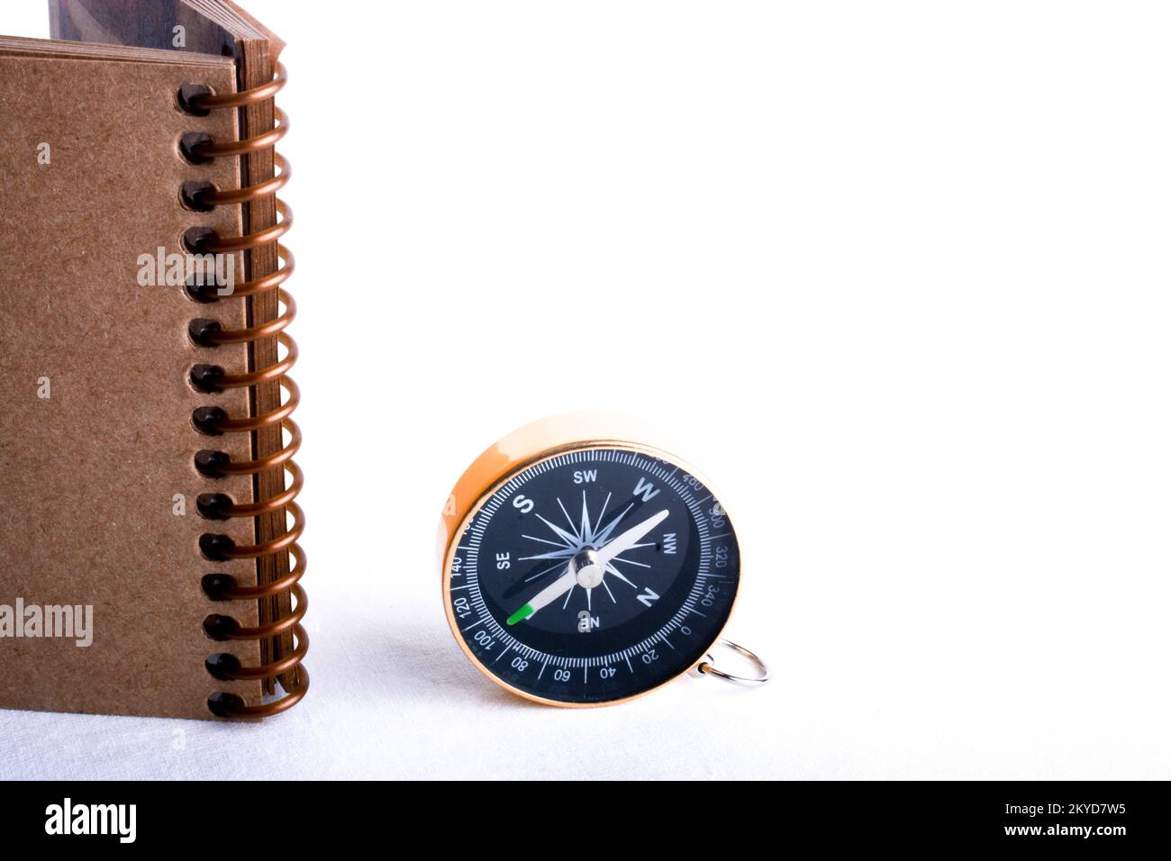 Compass by the side of a spiral notebook on a white background Stock ...