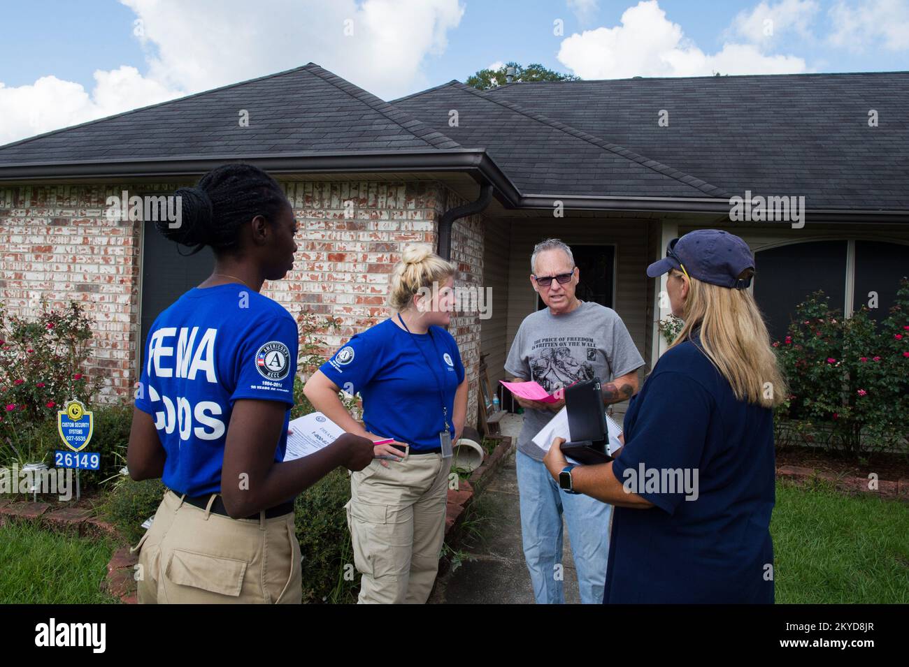 FEMA Disaster Survivor Assistant (DSA) Karyn Wolfe (right) and FEMA Corps members Nakiya Soloman (left) and Raven Rospierski answer questions from flood survivor Michael Jeffirs outside of his damaged home in Denham Springs, La. DSA teams canvasses neighborhoods daily in disaster affected areas, going door to door to ensure survivors have registered with FEMA and to report potential emergencies.. Louisiana Severe Storms and Flooding. Photographs Relating to Disasters and Emergency Management Programs, Activities, and Officials Stock Photo