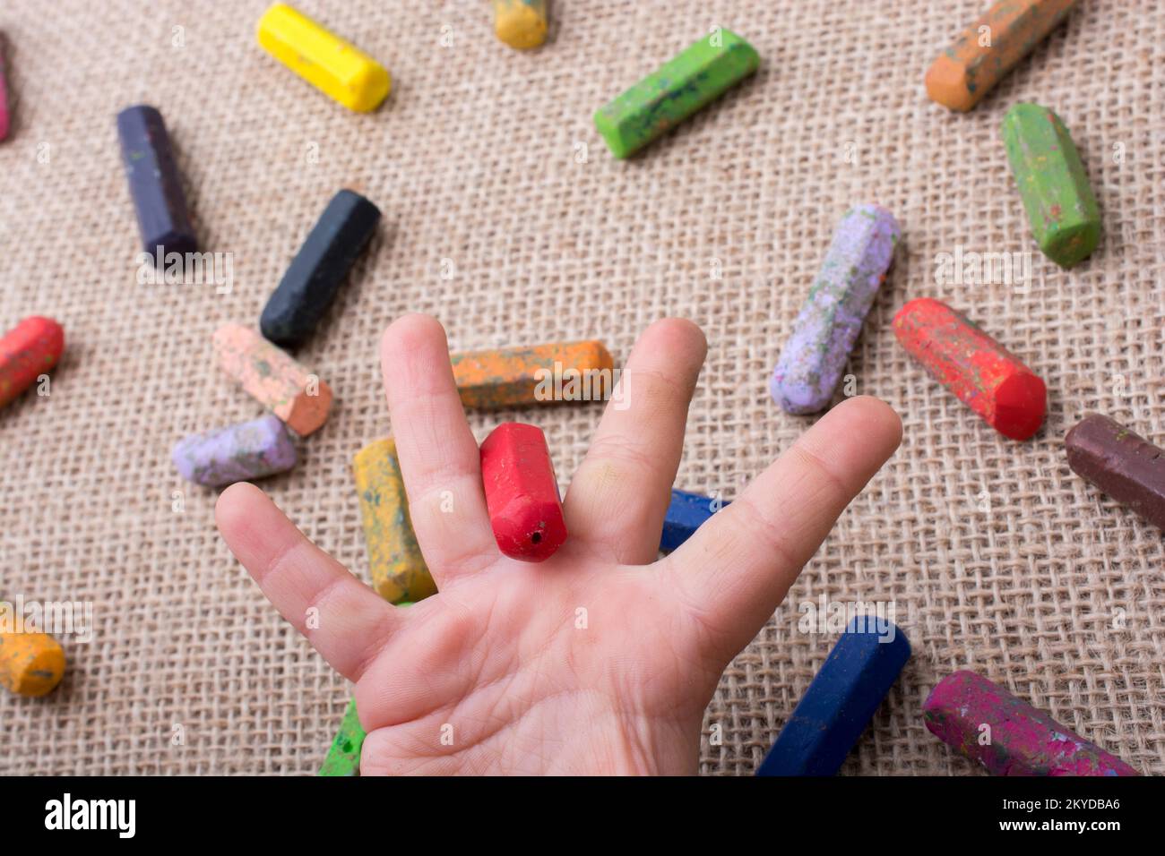 Used color crayons and a toddlers hand holding one Stock Photo Alamy