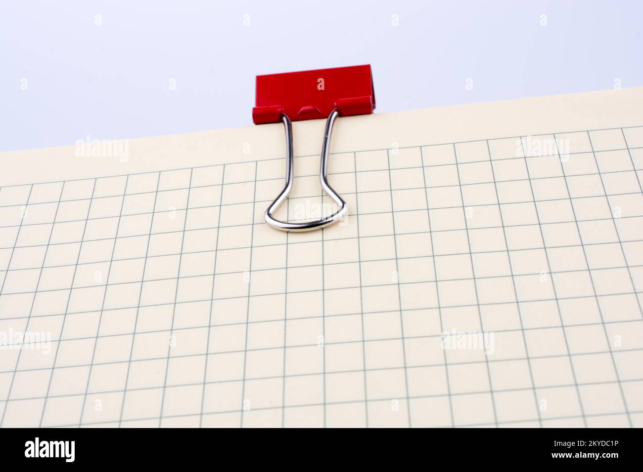 Colored paper clip on a checked notebook page Stock Photo