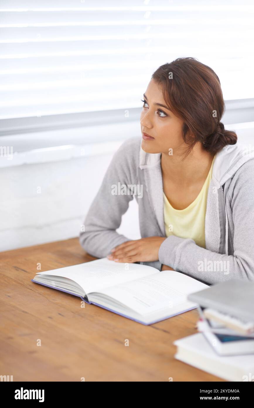 Trying to overcome a problem. A beautiful college student trying to overcome a study block in her dorm room. Stock Photo