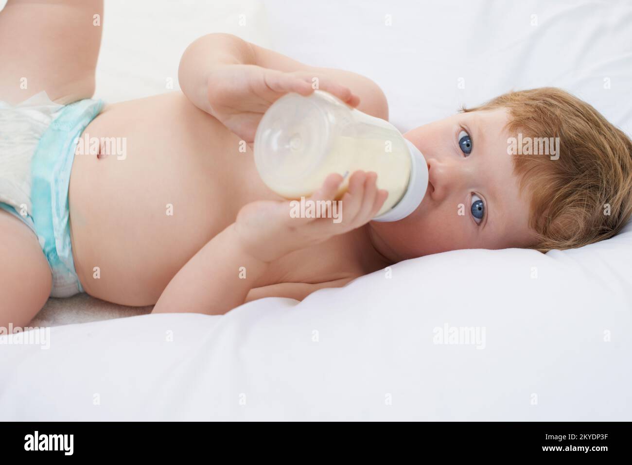 Relaxing with my formula. A sweet little baby lying down drinking a