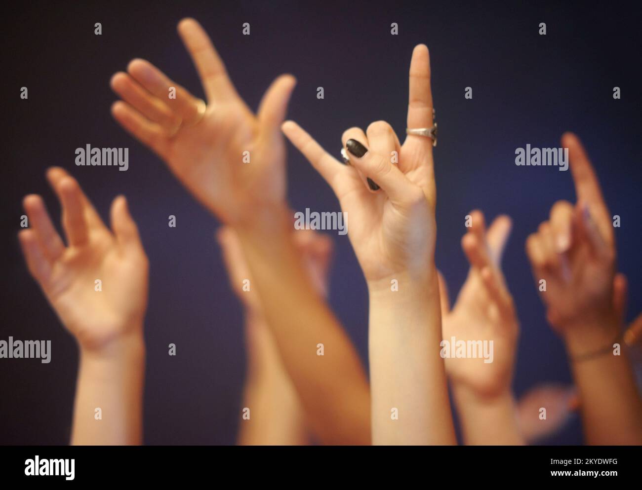 Reaching out to the performers. Cropped image of hands raised and reaching towards the stage gesturing rock on. Stock Photo