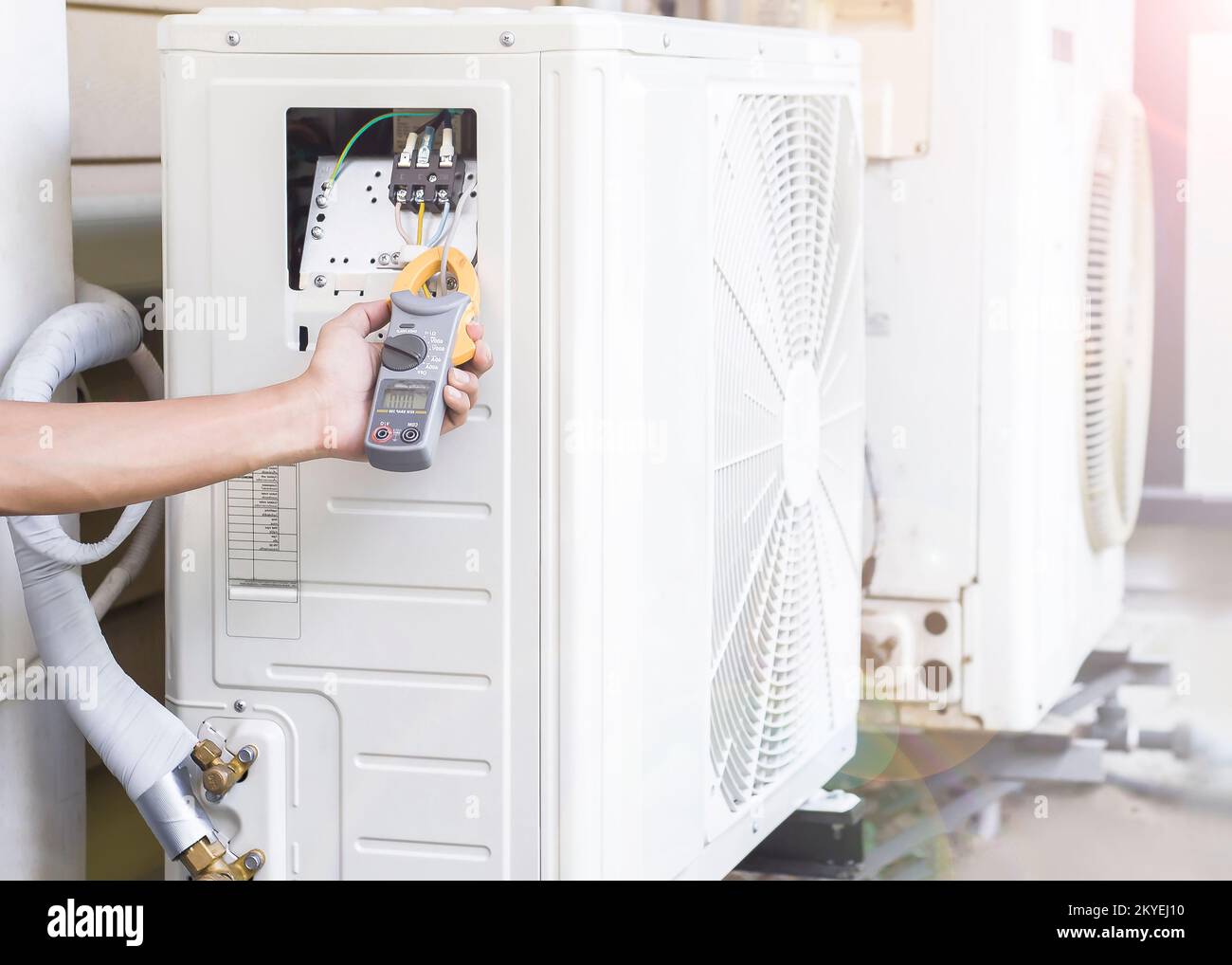 Air conditioner repairman using electricity meter to check air