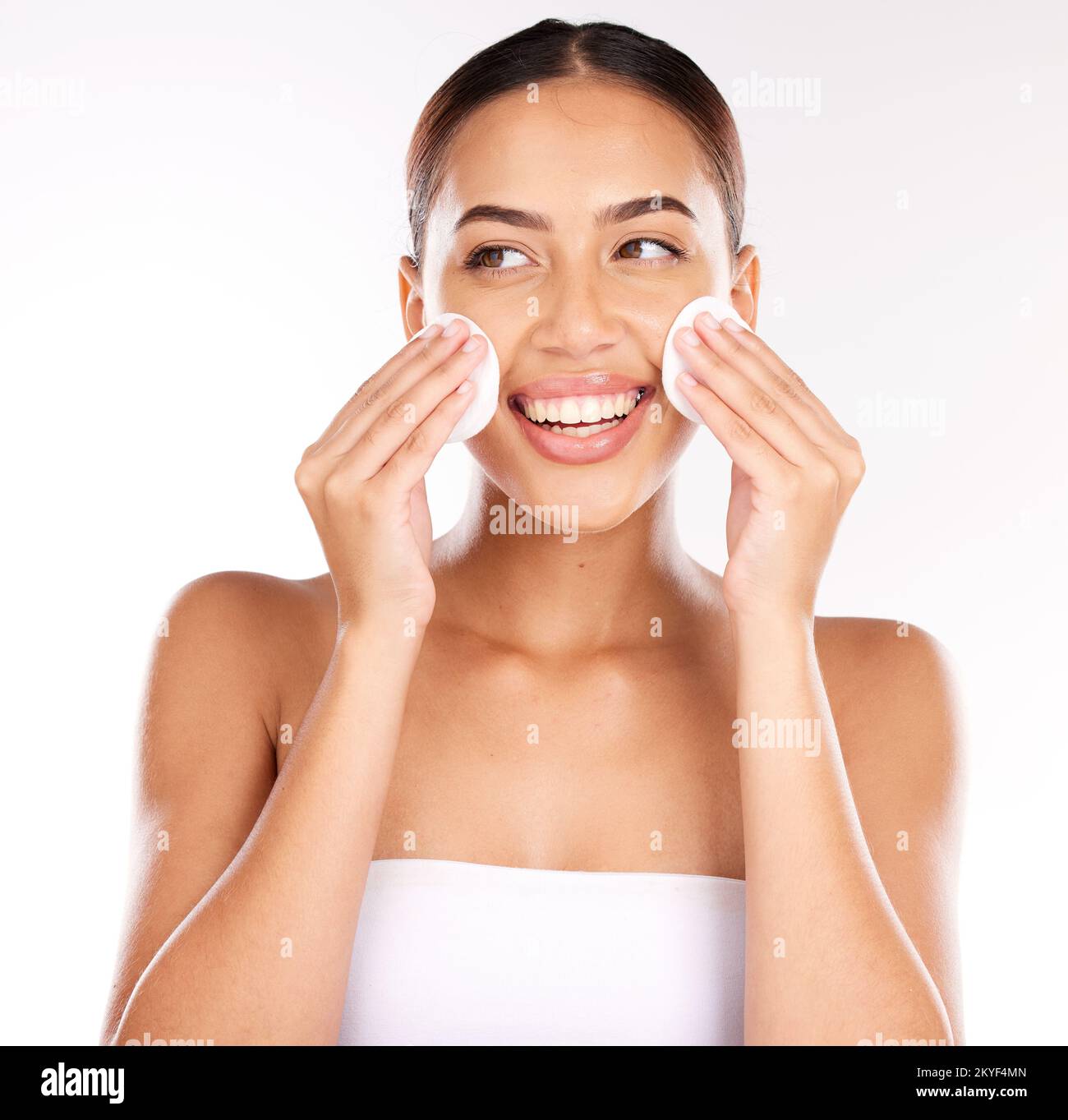 Face, beauty and woman with cotton pad in studio isolated on white background. Health, wellness and happy young female model from Brazil with facial Stock Photo