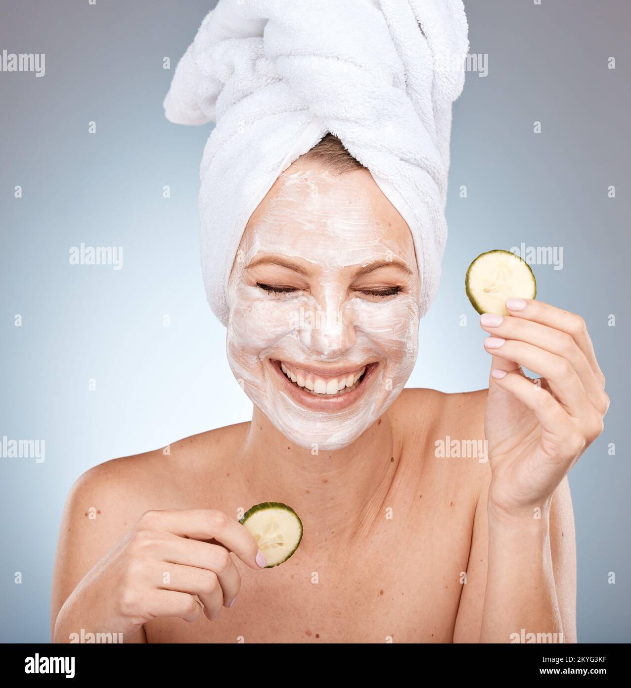 Laughing woman, skincare face mask and cucumber on studio background in