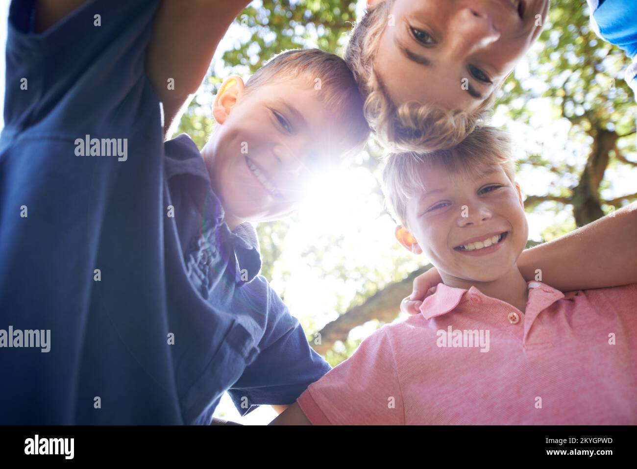 Theyre just mischief waiting to happen. Three brothers huddling together while playing outdoors in the bright sunshine. Stock Photo