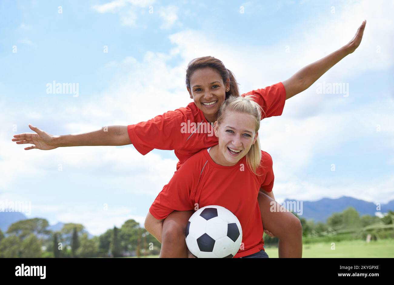 Celebrating a brilliant strike. a female soccer player carrying her teammate on her back in celebration. Stock Photo