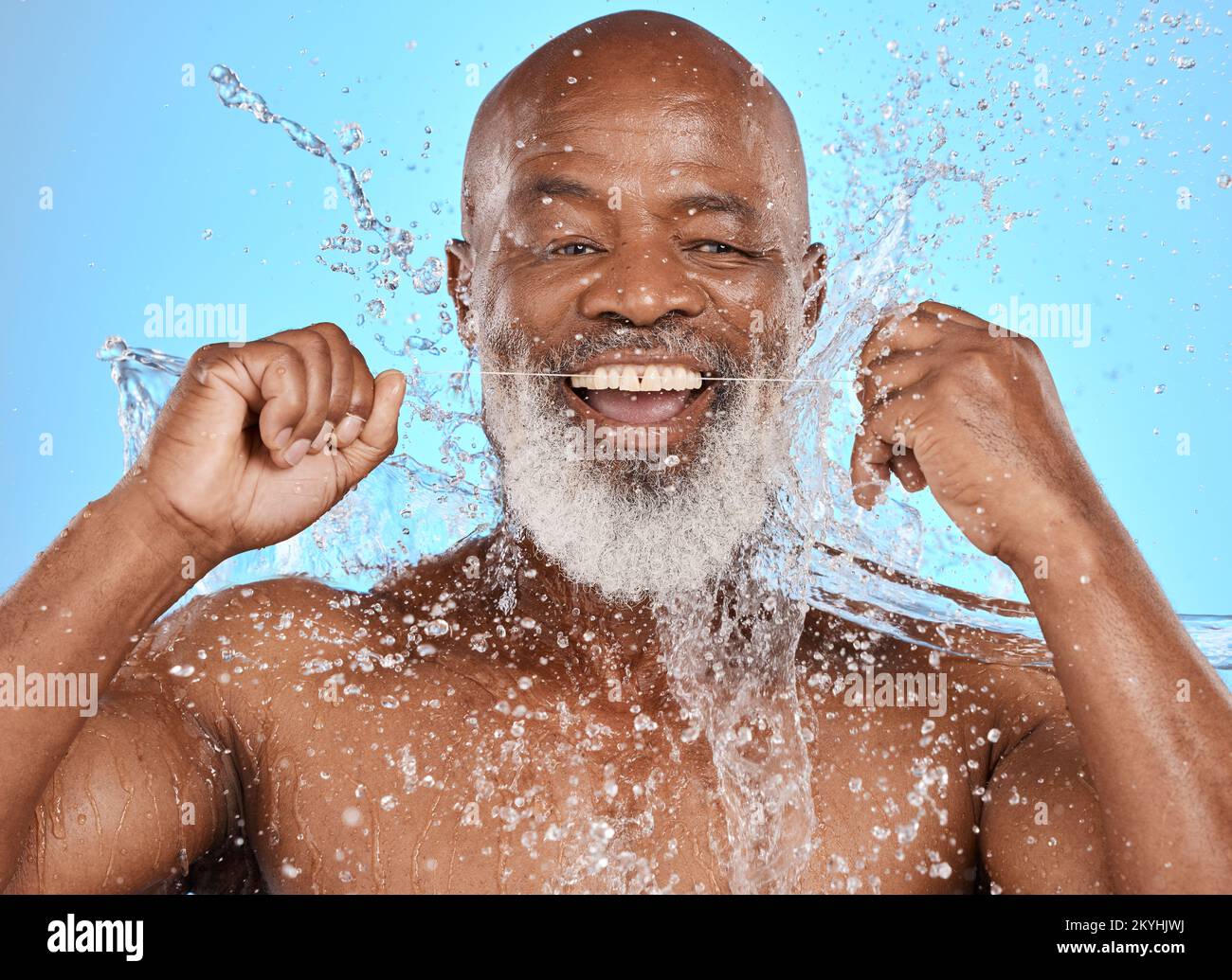 Oral, man floss and water with smile, wellness and on blue studio background. Portrait, mouth health or senior black male with dental hygiene, liquid Stock Photo