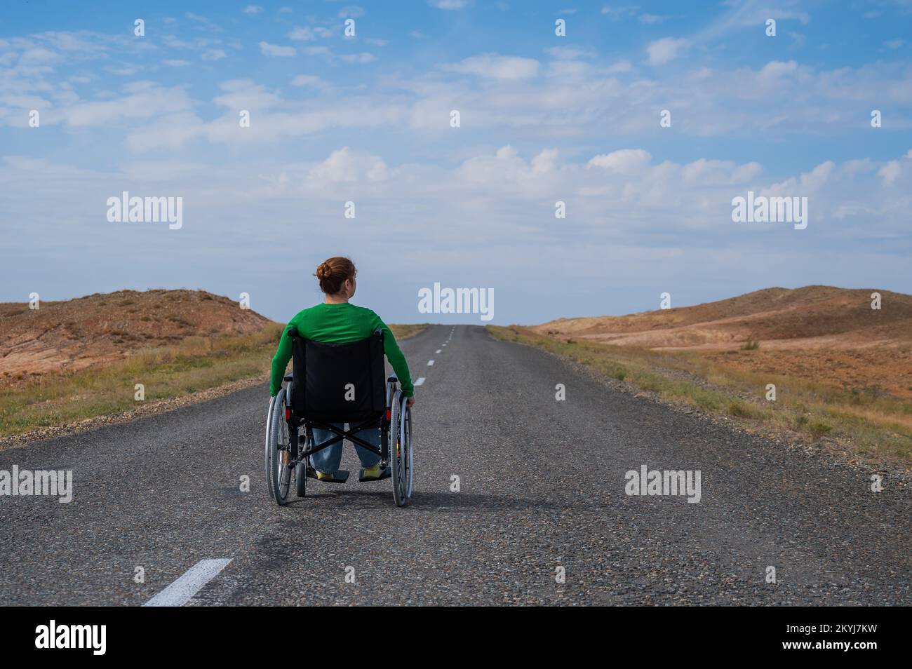 Woman in a wheelchair on a highway in the steppes Stock Photo Alamy