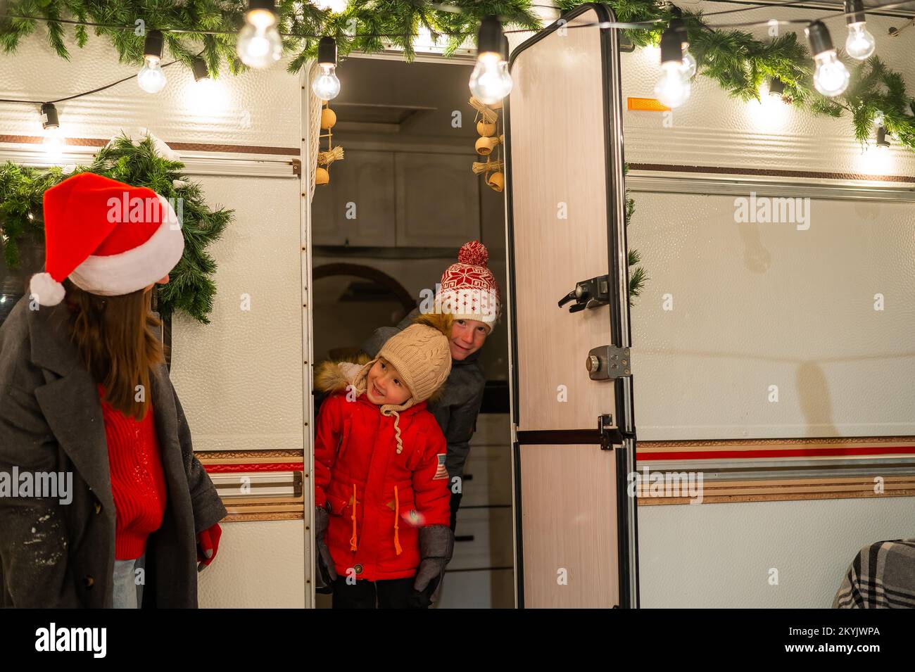 Caucasian woman and two with sons celebrate Christmas in a camper. Mom