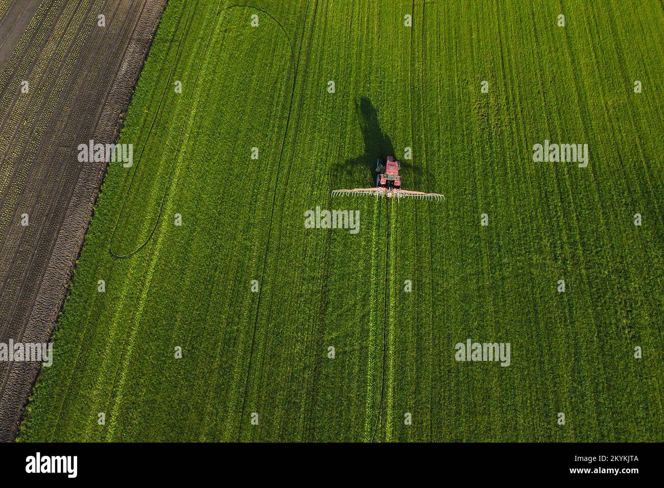Aerial view of tractor driving through crops on farm Stock Photo Alamy