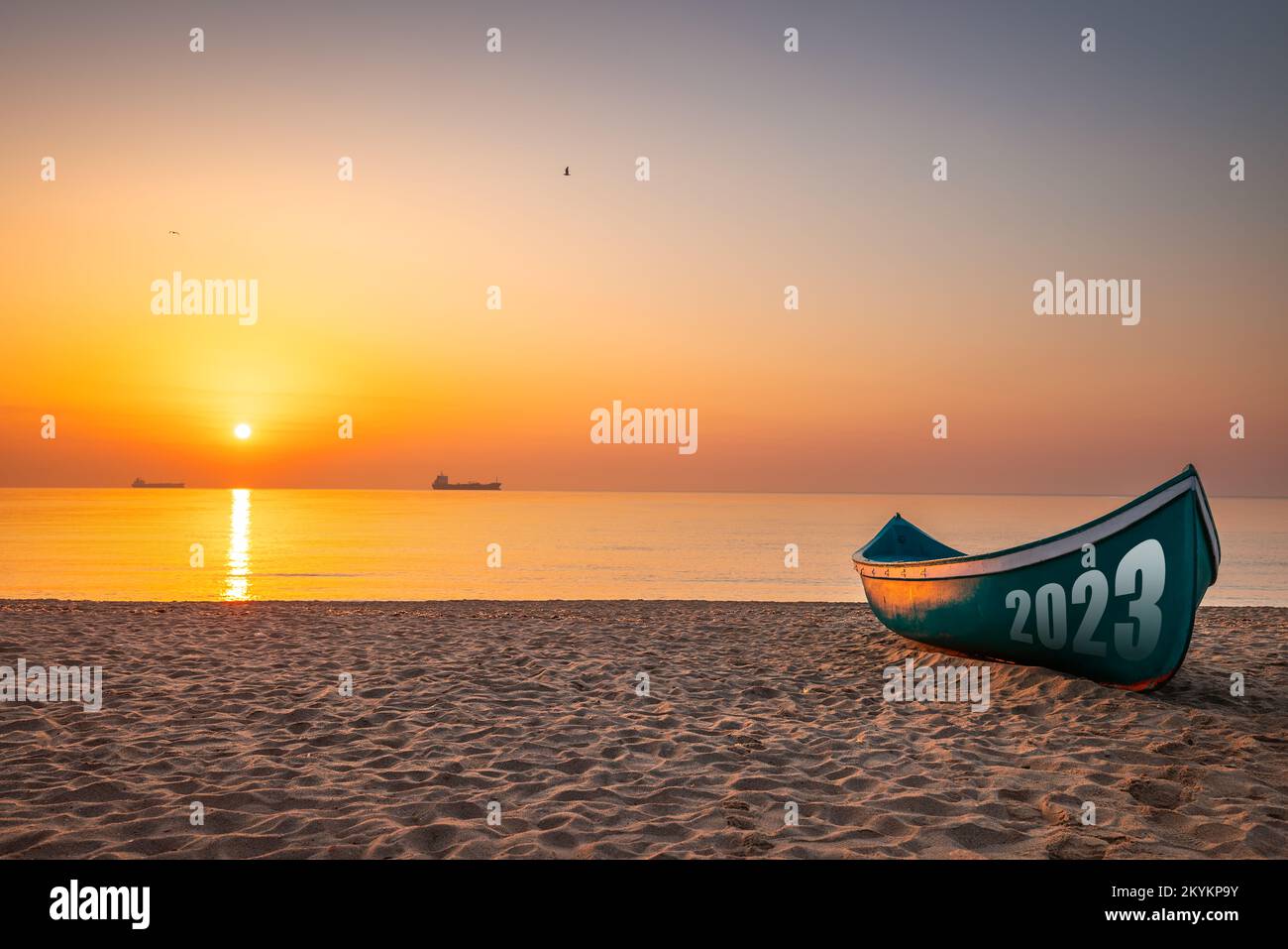 Happy new year 2023 relaxation morning on the beach concept. Fishing Boat and beautiful new sunrise or sunset on the seashore. Stock Photo