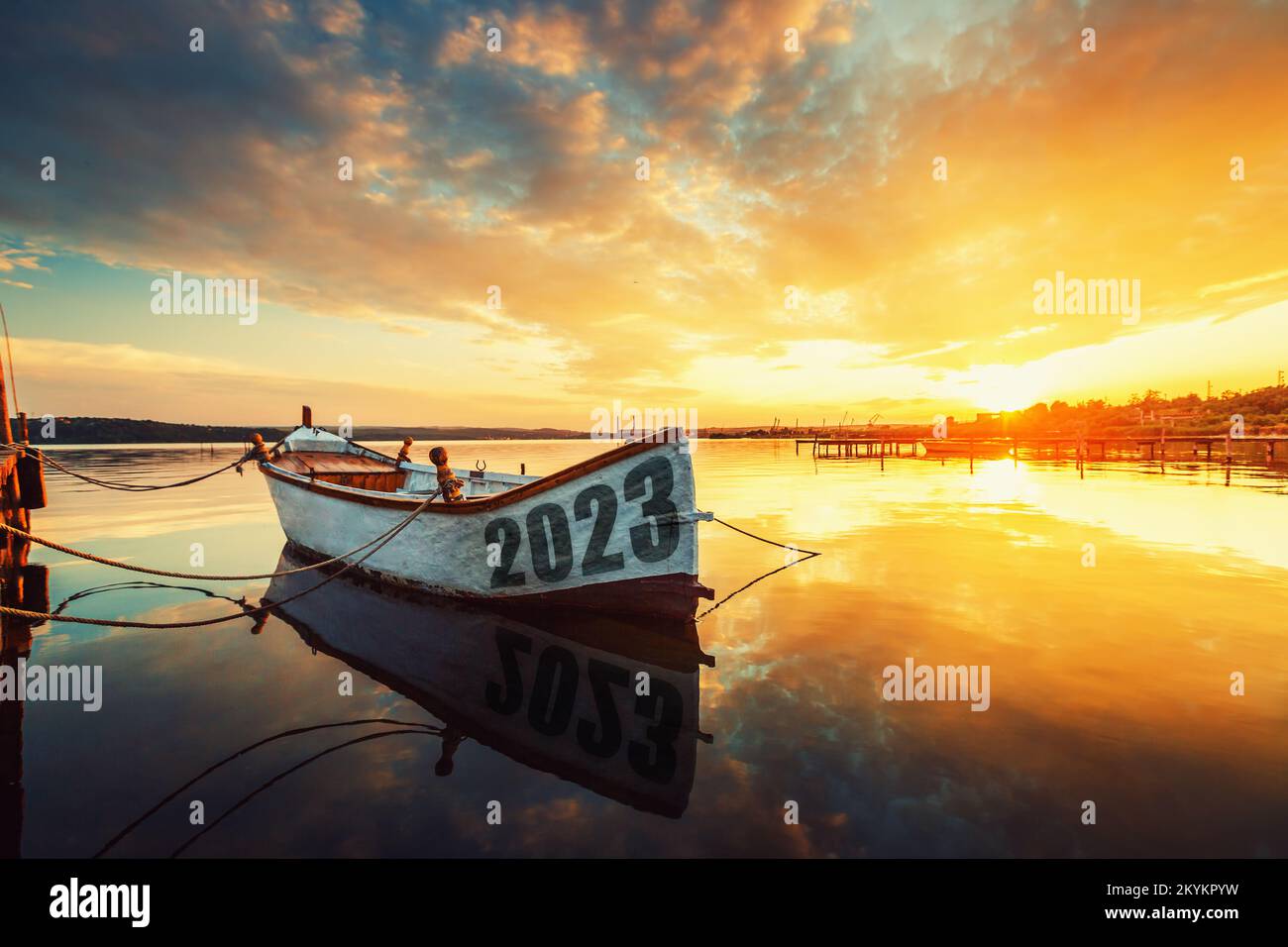 2023 happy new year concept. Fishing Boat on Varna lake with a reflection in the water at sunset. Nature landscape. Stock Photo