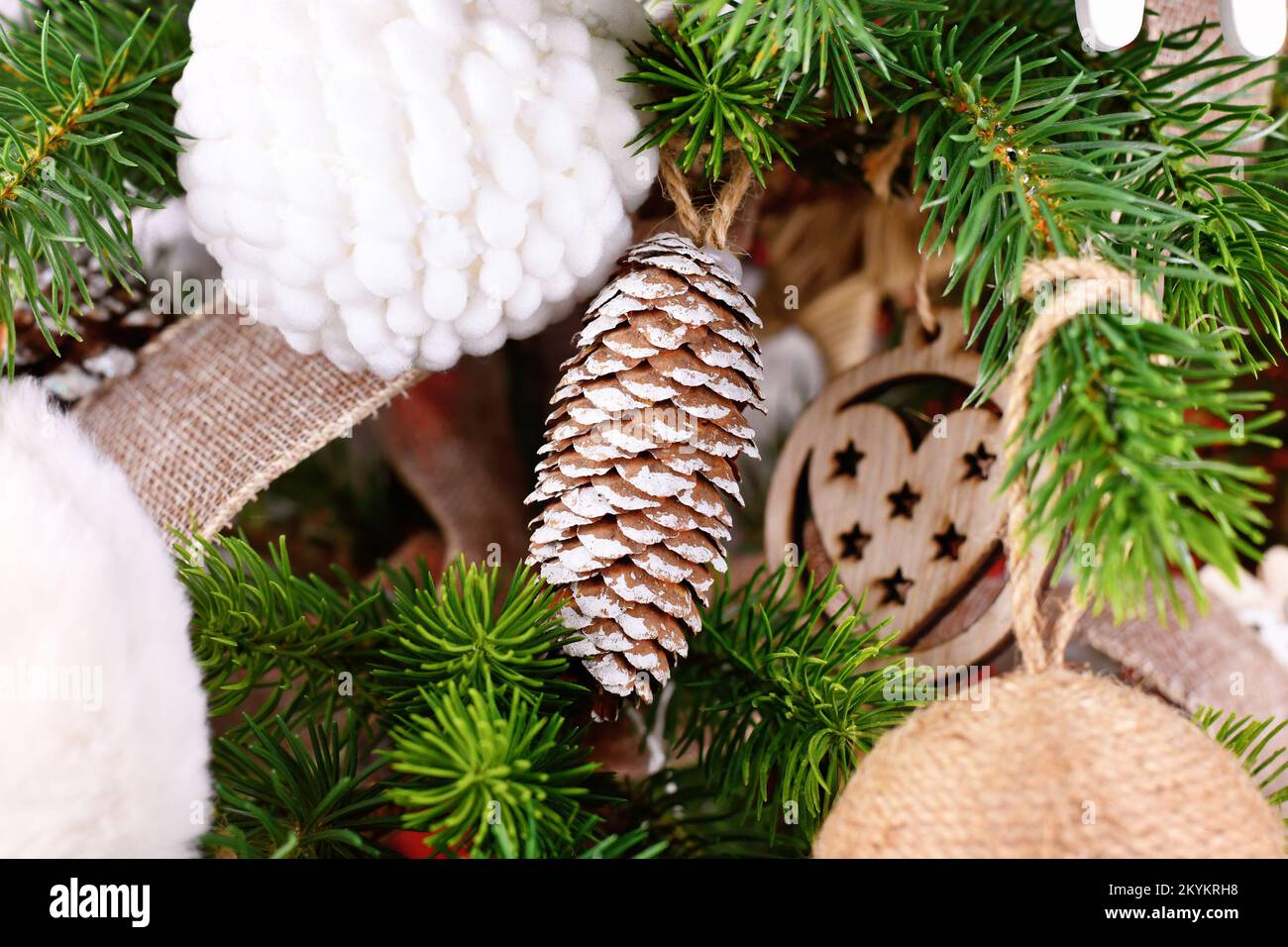 Natural Christmas tree ornament bauble made from pine cone with white paint Stock Photo
