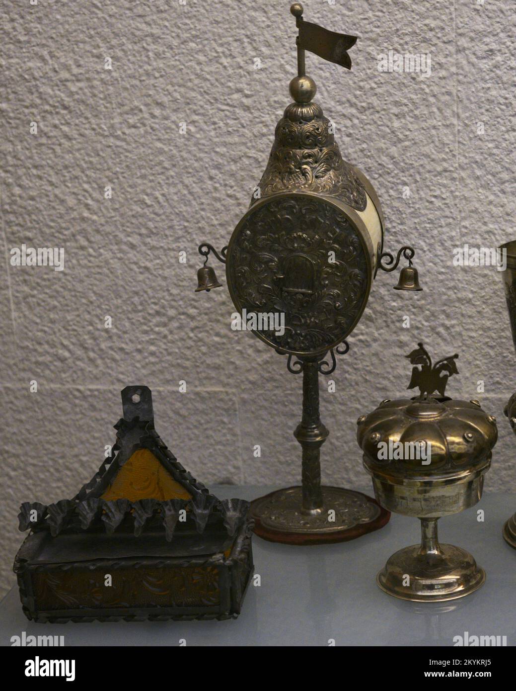 Left: lamp for the festival of Lights (Hanukkah). Late 19th century. Brass and glass. From Djerba (Tunisia). Center: perfumer for the Habdalah ceremony. 19th-20th centuries. Silver and ivory, inscriptions in Hebrew. From Central Europe. Right: Kiddush cup for the Sabbath feast with lid and spice container. Hebrew inscriptions. 20th century. Silver. From Central Europe. Sephardic Museum. Toledo. Castile-La Mancha. Spain. Stock Photo