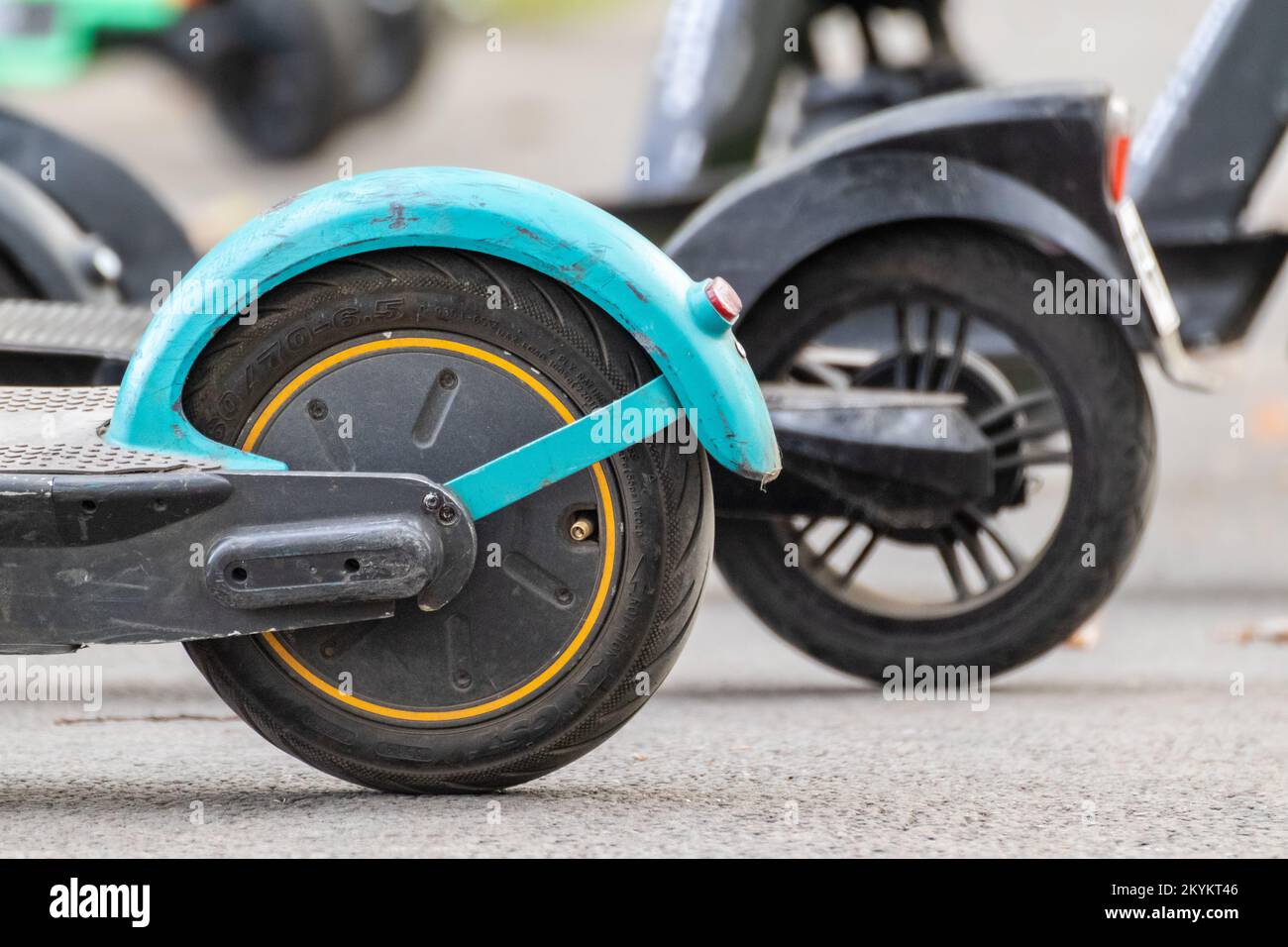 Green Electric Scooter rental standing on asphalt road. Escooter