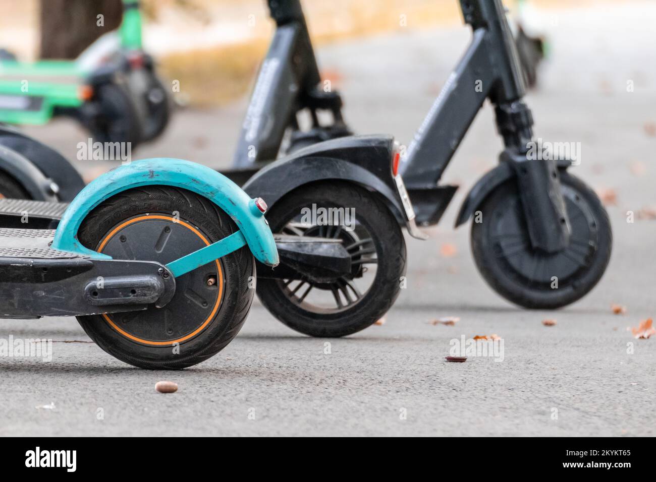 Electric Scooter rental on asphalt road with blurred background. Escooter wheels closeup