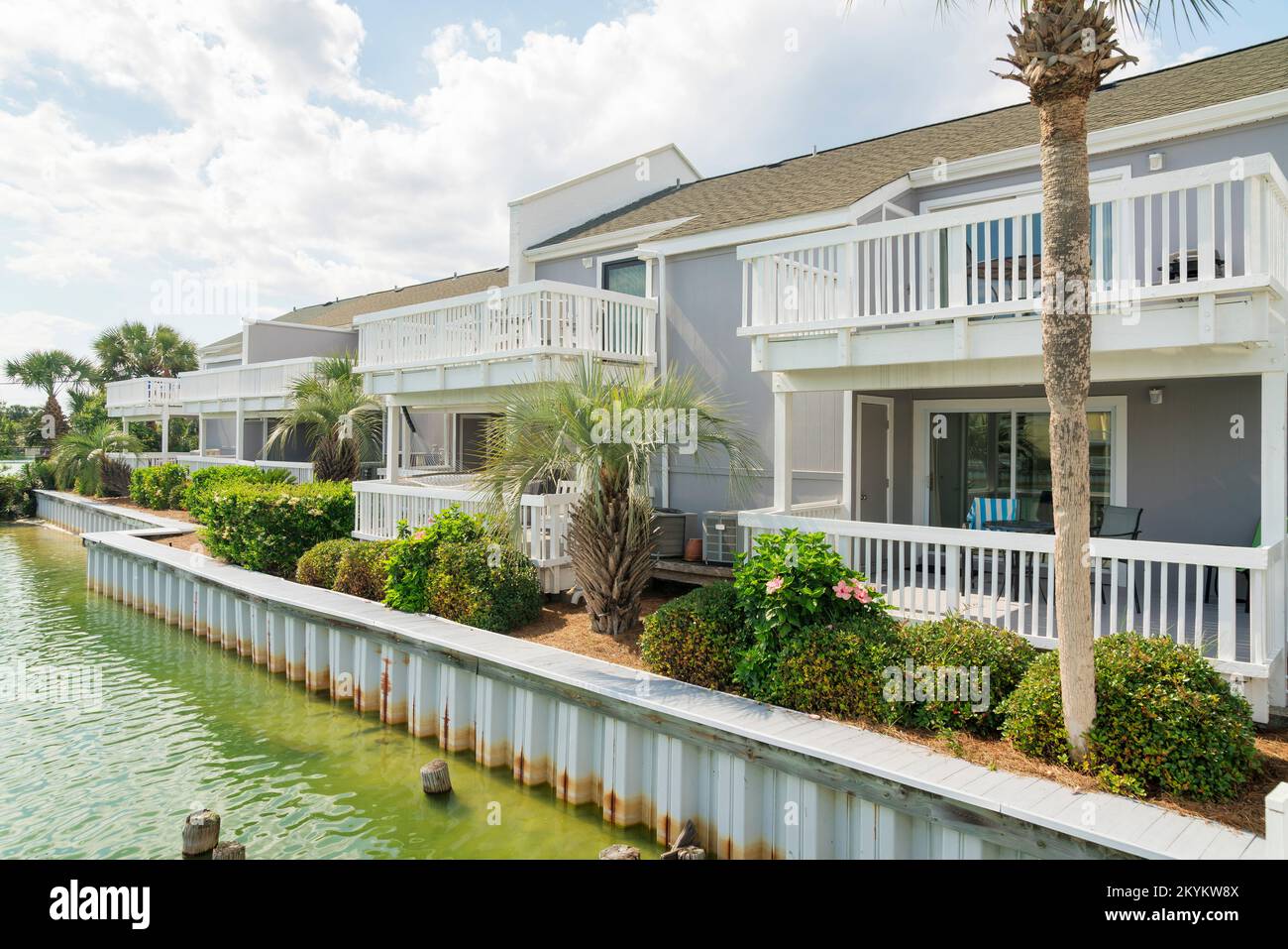 Row of houses with balconies near the steel retaining wall of a lake ...