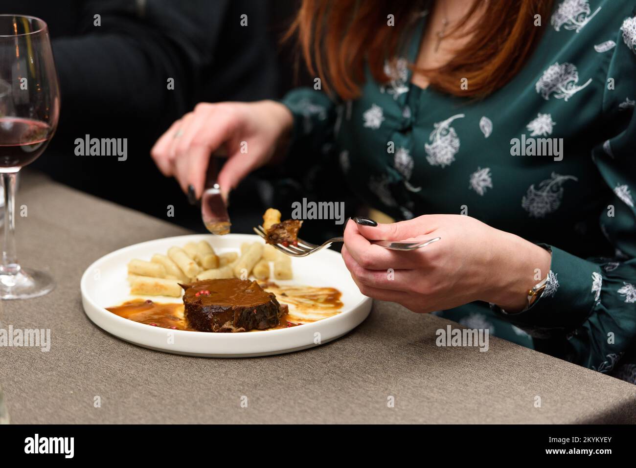 Woman eating pasticada with gnocchi, beef stew in a sauce. Croatian cuisine Stock Photo