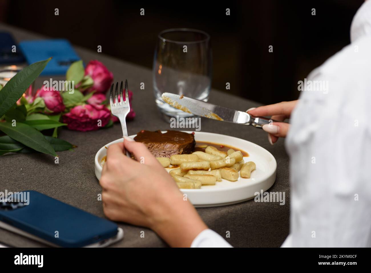 Woman eating pasticada with gnocchi, beef stew in a sauce. Croatian cuisine Stock Photo