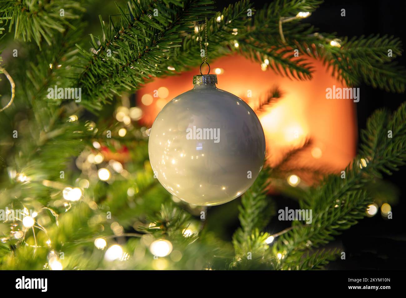 Christmas background. Xmas tree decoration bauble and lights close up view, burning fireplace, copy space. Stock Photo