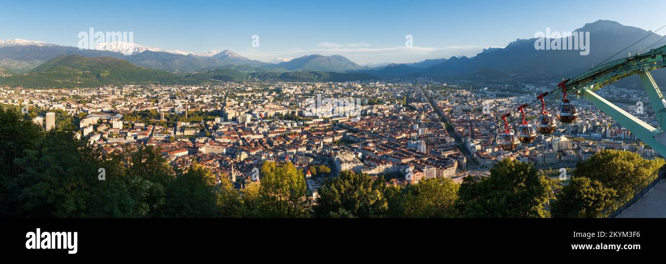 Panoramic skyline of the city of Grenoble at sunset with cable cars of Fort de la Bastille. Summer in Isere, Rhone-Alpes region, France Stock Photo