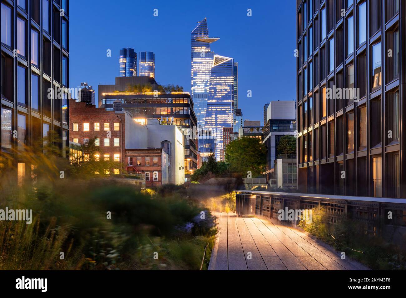 New York City Highline promenade in Chelsea. Elevated greenway with Hudson Yards skyscrapers in evening. Manhattan Stock Photo