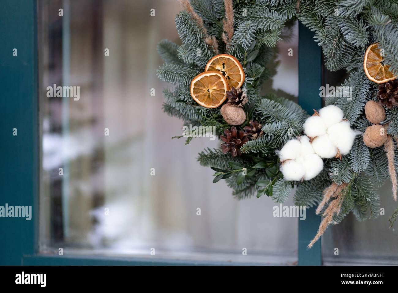 Christmas wreath on the background of a glass blue door with space for text. Christmas concept Stock Photo