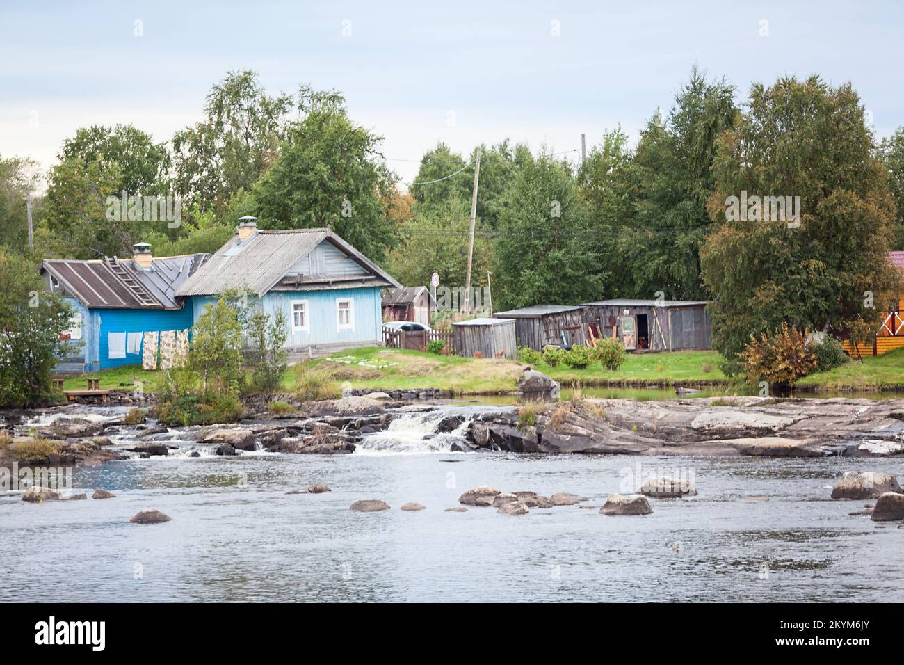 Old wooden house with sheds on the banks of the Nizhniy Vyg river, Belomorsk city, Karelia, northern Russia Stock Photo