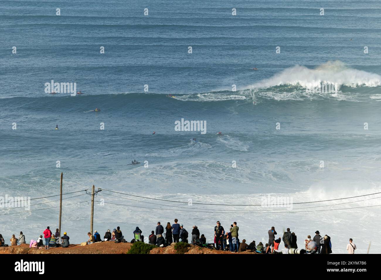 People watching the big giant waves crashing in Nazare, Portugal. Biggest waves in the world