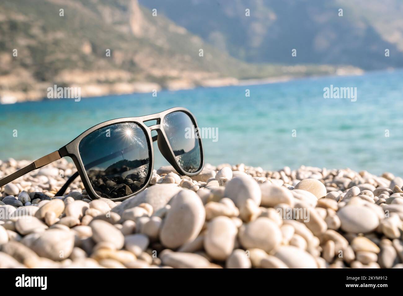 Sunglasses on the sea beach against the backdrop of the sea. Vacation, relax, summer concept. High quality photo Stock Photo